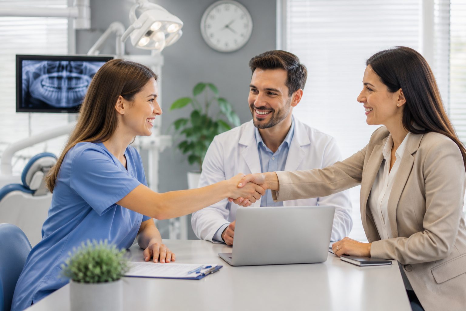 A dental specialist and a practice owner shaking hands across a desk after a successful introduction.